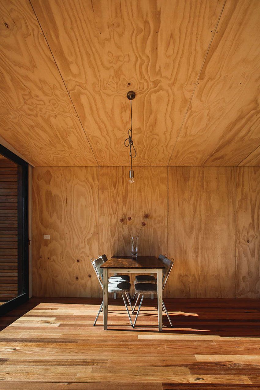 Sunlight across a quiet dining table and the timber walls of the cabin.